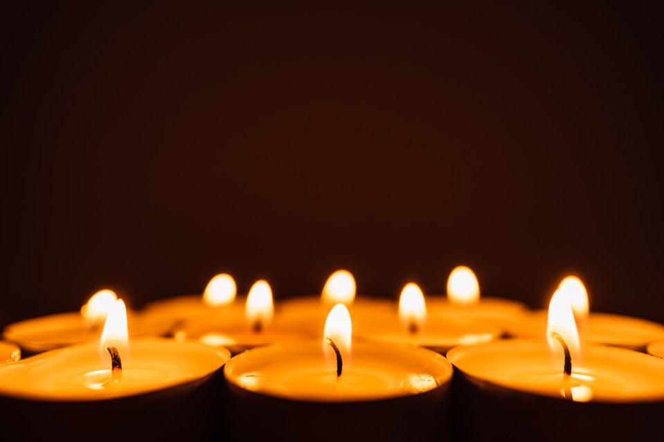 Burning candles in a row in the dark.